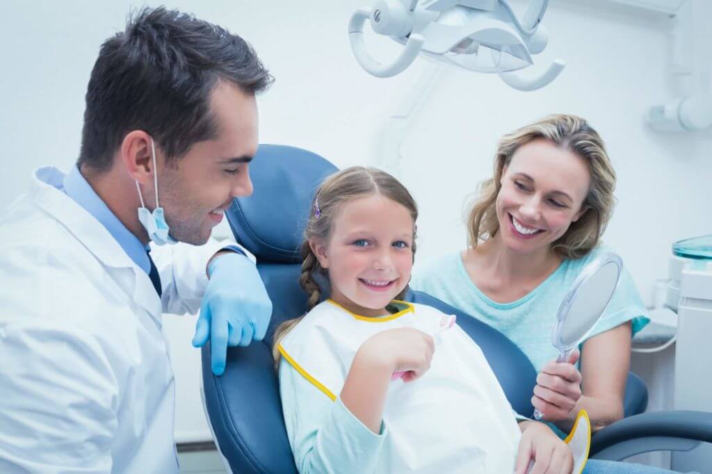 smiling child who has overcome her fears of visiting the pediatric dentist