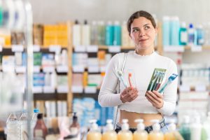 Woman chooses a toothbrush with soft or medium bristles based on the recommendation of a dentist