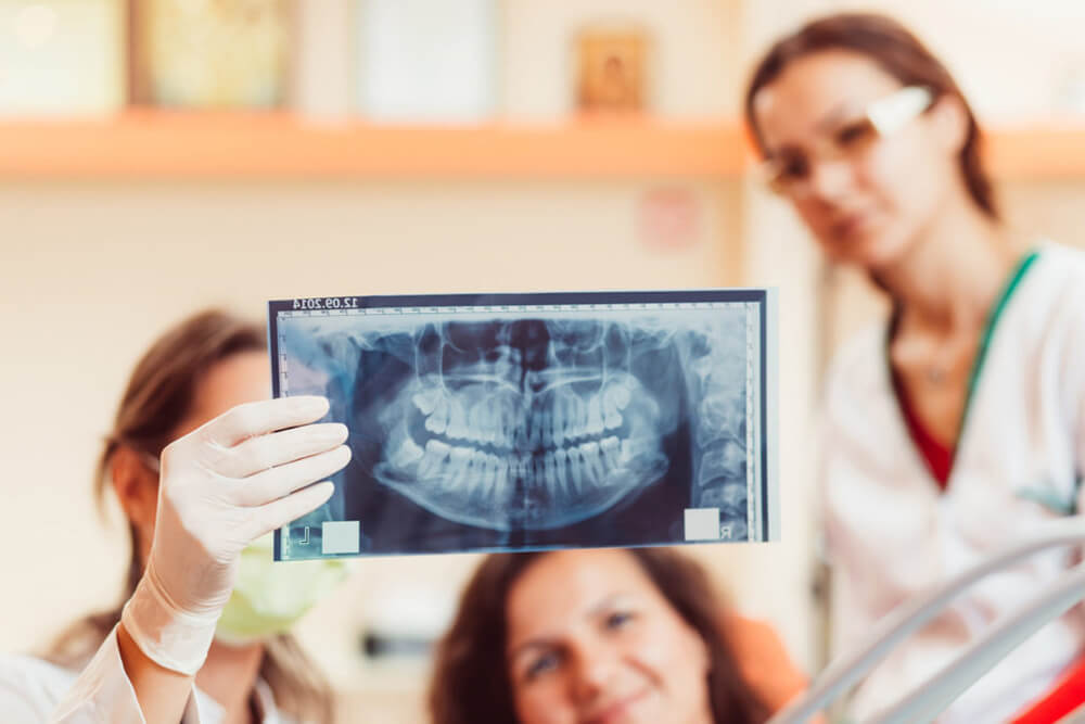 Dental professionals examine a patient’s X-ray.