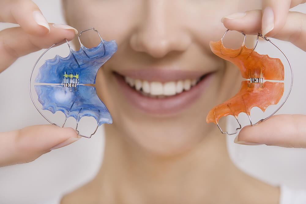 Woman holding two different retainers