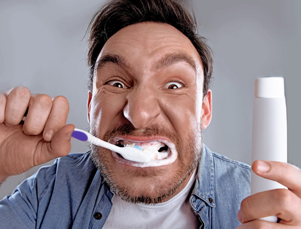 Man vigorously brushing his teeth.