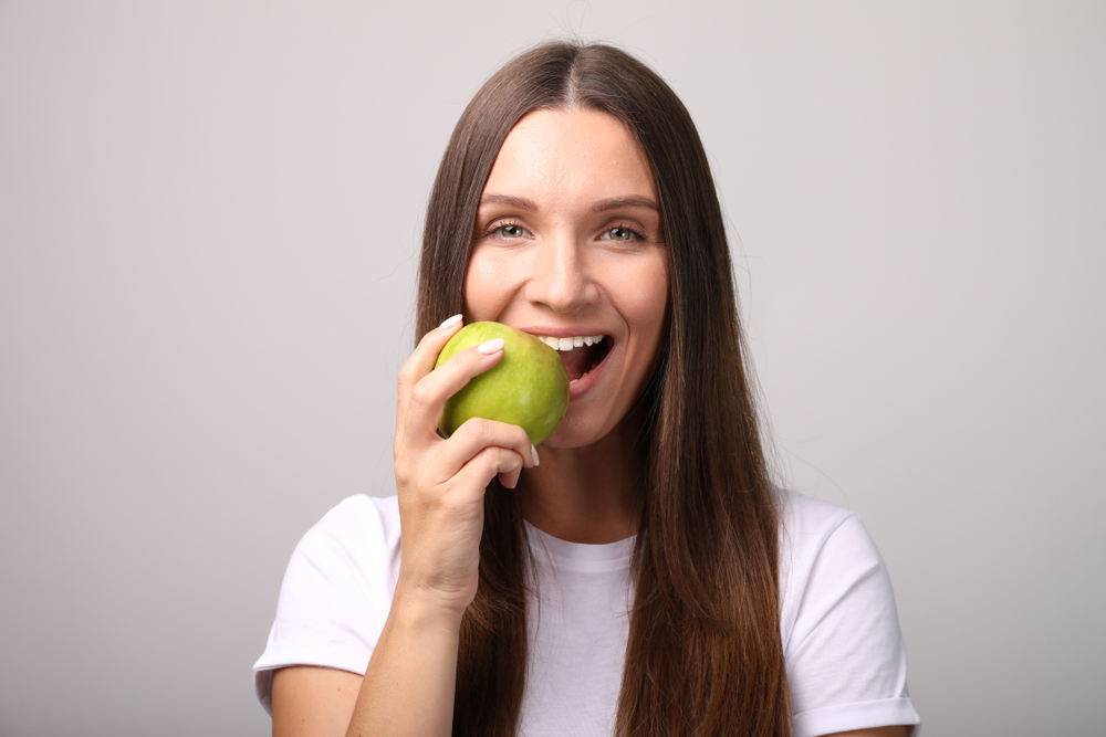 Young woman eating an apple