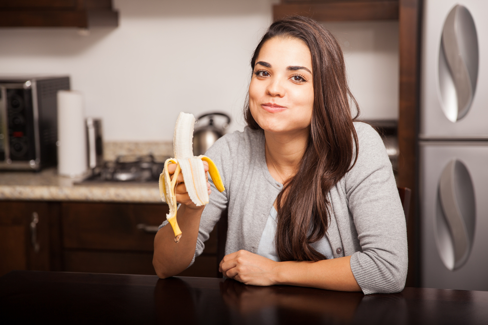 Young woman eating a banana