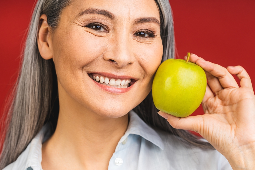Smiling Senior Woman Holding an Apple