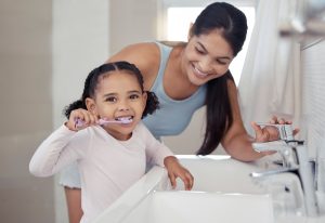 Girl and Mom Brushing Teeth