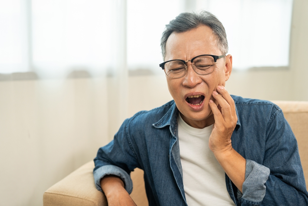 Man Holding His Cheek in Pain